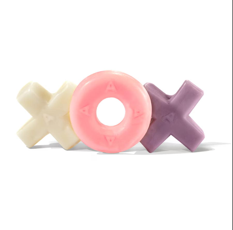 Three Hugs & Kisses Gummi candies from Minonk Chocolate Company—white "X" on the left, pink "O" in the center, and purple "X" on the right—are arranged side by side against a plain white background.